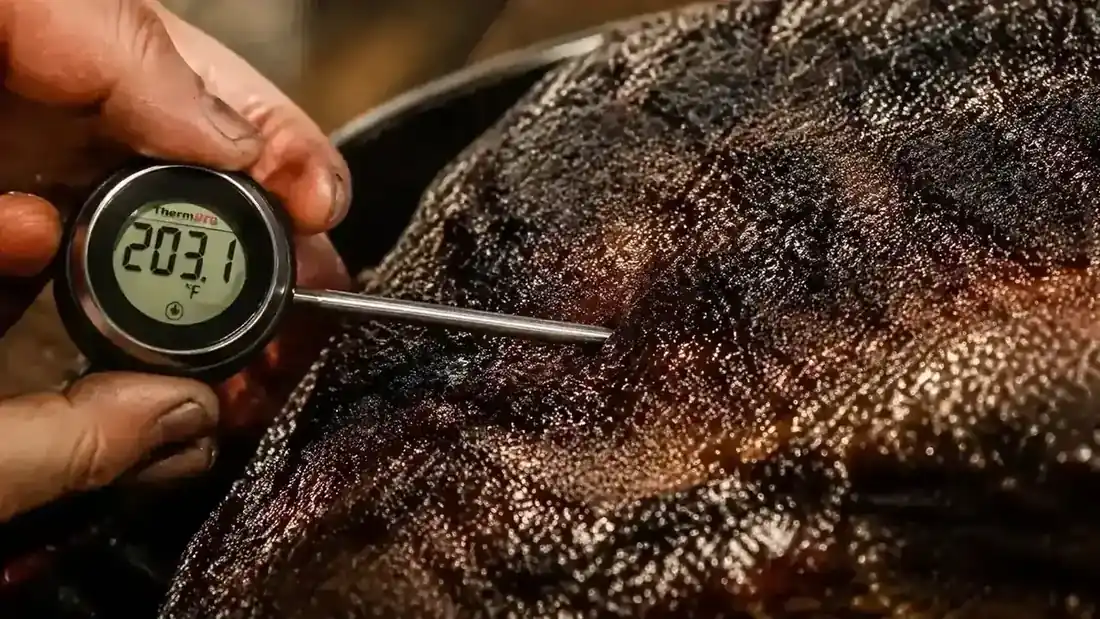 Perfectly sliced brisket with visible smoke ring resting on a wooden cutting board